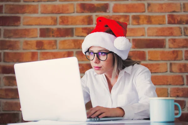 Frau mit Weihnachtsmütze und Laptop — Stockfoto