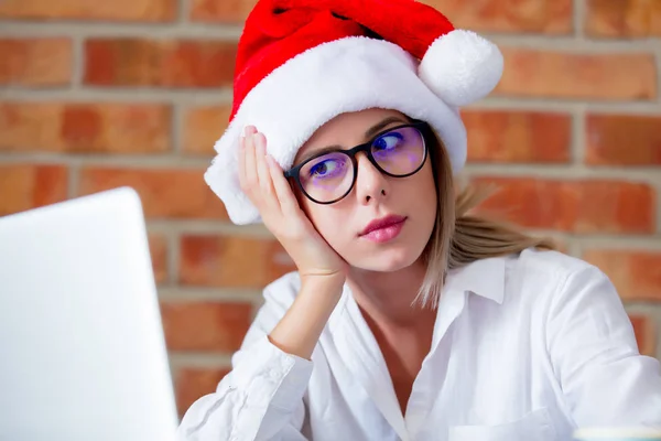 Woman in Christmas hat and laptop computer — Stock Photo, Image