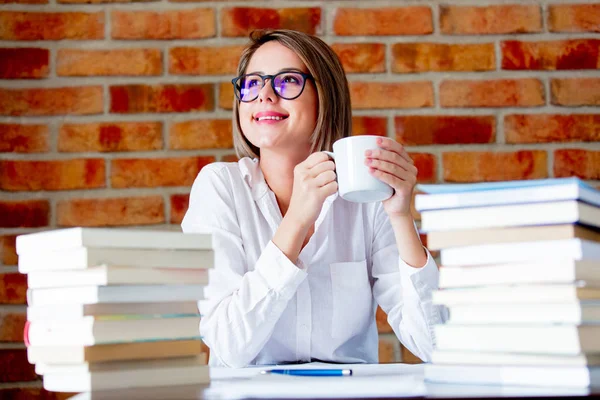 Young woman with cup of coffee and books Stock Photo