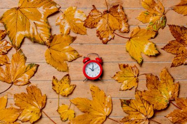 küçük vintage kırmızı çalar saat ile akçaağaç ahşap masada bırakır