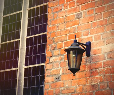 Kırmızı tuğla duvar pencere yakınındaki eski lamba