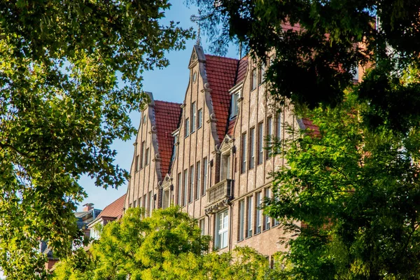 Stary dom fasada z drzewa na pierwszym planie — Zdjęcie stockowe