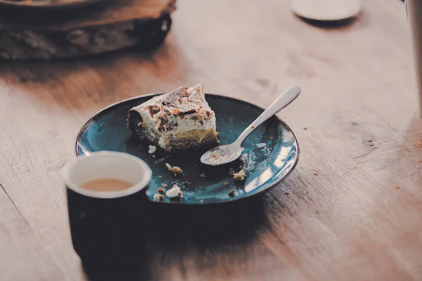 Teller mit gegessen Kuchen und Löffel auf Holztisch — Stockfoto