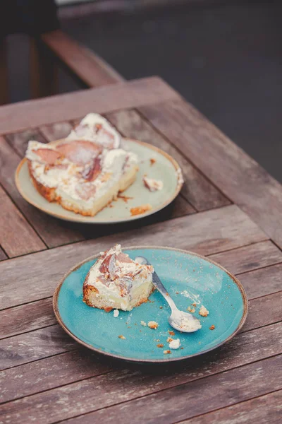 Teller mit gegessen Kuchen und Löffel auf Holztisch — Stockfoto