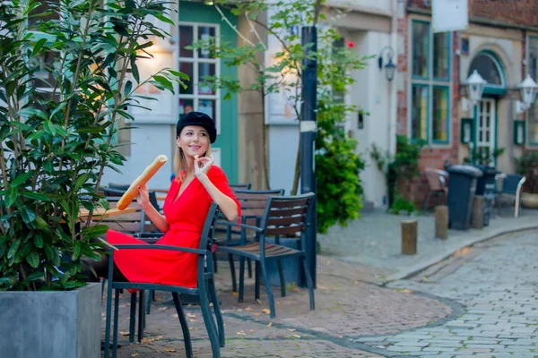 穿着红裙子的女士坐在咖啡馆里 — 图库照片