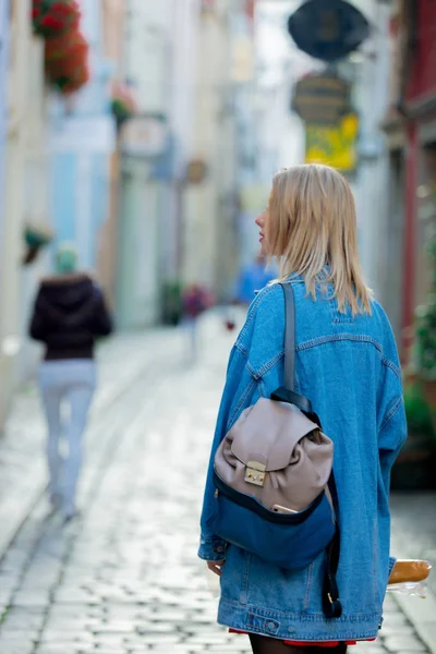 在不来梅中世纪街头穿牛仔裤夹克的年轻女士 — 图库照片