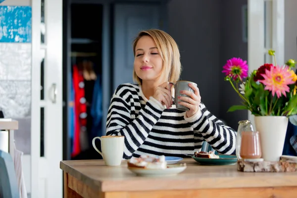 girl at kitchen with cup in breakfast time.