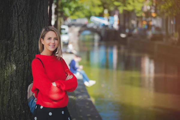 Chica en suéter rojo y mochila en el puente en Amsterdam — Foto de Stock