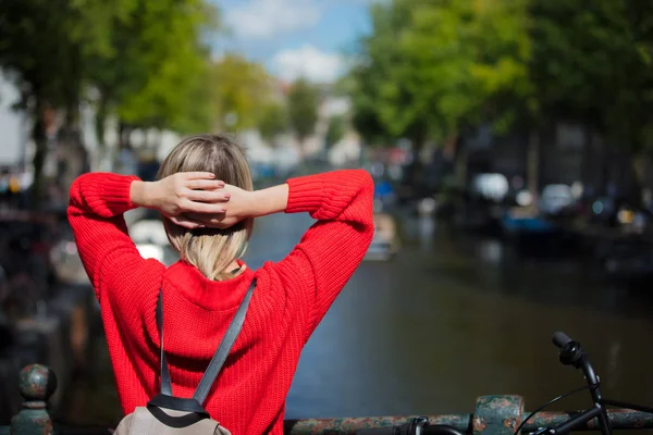 Menina em camisola vermelha e mochila na ponte em Amsterdã — Fotografia de Stock