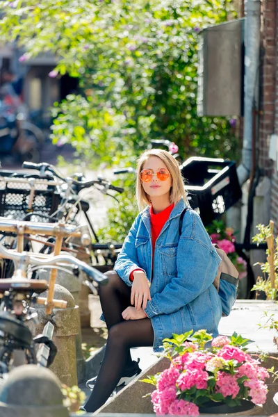 Девушка сидела на улице в Амстердаме — стоковое фото