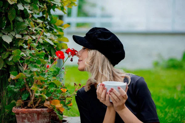 Meisje met kop koffie in de tuin — Stockfoto