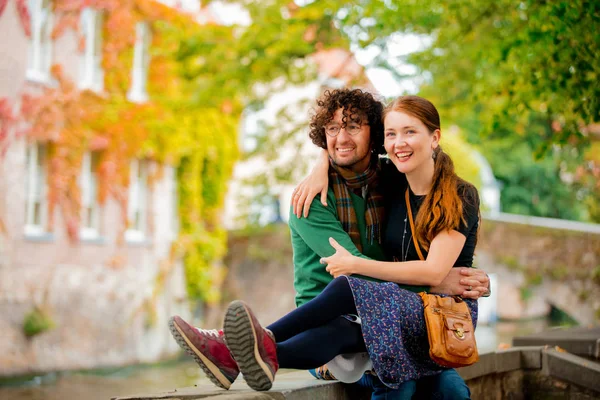 Giovane ragazza e uomo seduti insieme vicino al canale di Bruges — Foto Stock