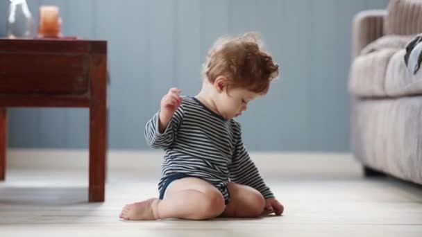 Baby play με το κομμάτι του ξύλου σε ένα πάτωμα — Αρχείο Βίντεο
