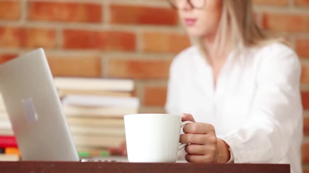 Mujer joven con taza y computadora portátil — Vídeo de stock