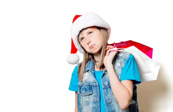 Girl in Christmas hat with shopping bags — Stock Photo, Image