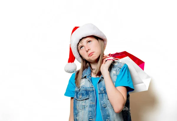 Menina em chapéu de Natal com sacos de compras — Fotografia de Stock