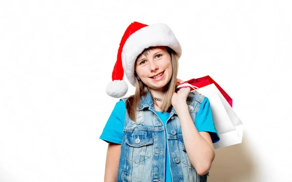 Menina em chapéu de Natal com sacos de compras — Fotografia de Stock