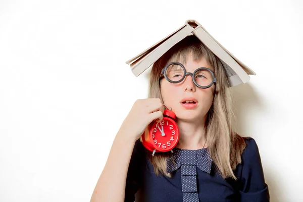 Nerd flicka i glasögon med böcker och väckarklocka — Stockfoto
