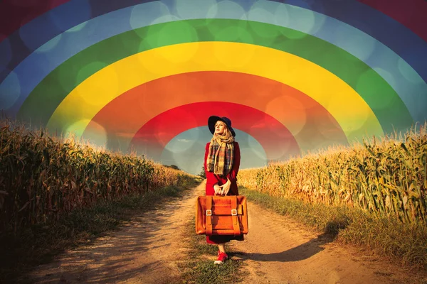 Девушка с чемоданом рядом с кукурузным полем — стоковое фото