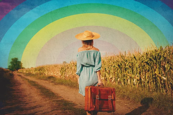 Girl with suitcase walking along a rural road — Stock Photo, Image