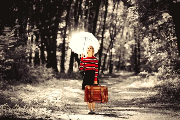 Dziewczyna z parasolem i walizkę w jesienny park — Zdjęcie stockowe