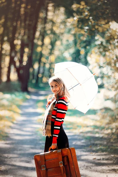 Menina com guarda-chuva e mala no parque de outono — Fotografia de Stock