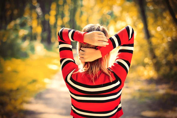 Parte de trás de uma menina de camisola vermelha em um parque — Fotografia de Stock