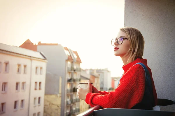 Девушка с чашкой сидя на балконе — стоковое фото