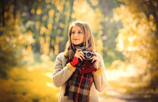 Flicka med kameran i en höst park — Stockfoto