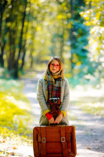 Girl with suicase in a park — Stock Photo, Image