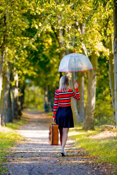 Fată cu umbrelă și valiză în parcul de toamnă — Fotografie, imagine de stoc