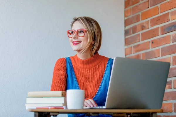 Ragazza con notebook seduta e al lavoro — Foto Stock