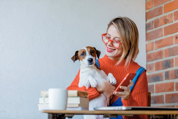 Дівчина сидить за столом з комп'ютером і собакою — стокове фото