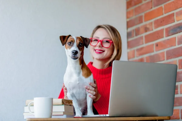 Ragazza sititng a tavola con computer e cane — Foto Stock