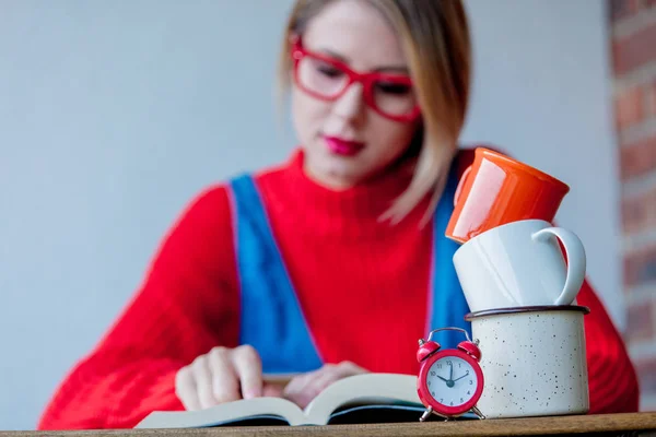 Menina cansada com xícaras de café e livros — Fotografia de Stock