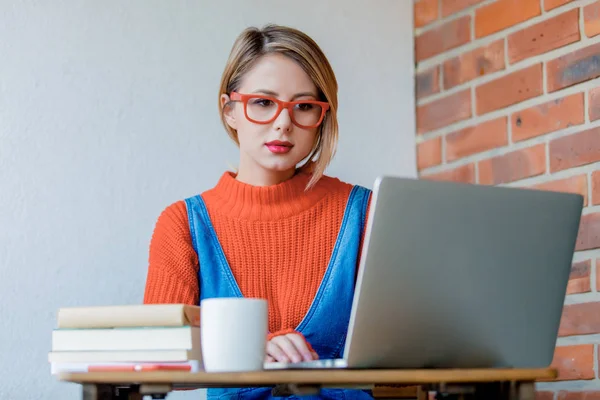 Ragazza con notebook seduta e al lavoro — Foto Stock