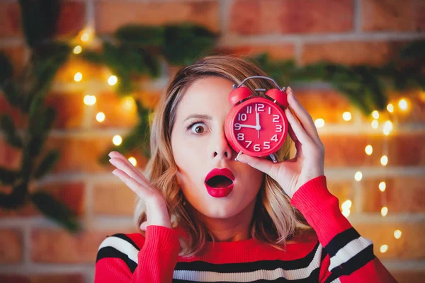 クリスマスに目覚し時計が付いて赤いストライプ セーターの少女の肖像画の背景をライトします — ストック写真