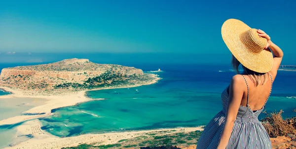 若いですRedhead女の子で帽子とドレスで海の海岸線とともにBalos クレタ島 ギリシャ — ストック写真