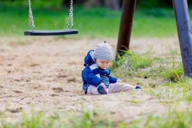 Küçük bir çocuk oyun bahçesi yalnız bir parkta, kum.