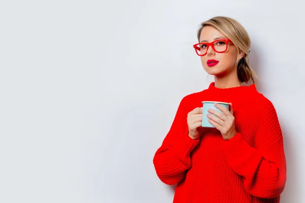 白い背景に 分離したコーヒー カップの赤いセーターの美しい白人女性の肖像画 — ストック写真