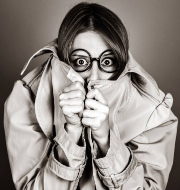 Kızıl saçlı kız gözlük ve pelerin saklanıyor. Görüntü siyah beyaz renk tarzı