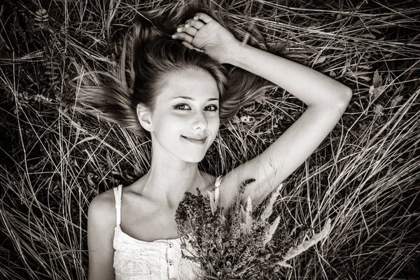红头发的女孩躺在草地上 黑白相间的图像 — 图库照片