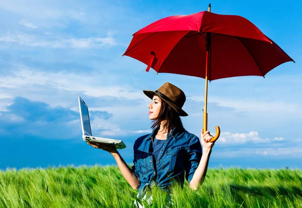 Jovem com guarda-chuva e laptop — Fotografia de Stock