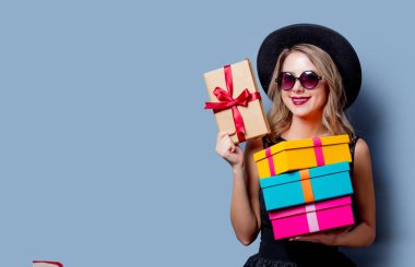 Siyah elbise ve şapka hediye kutuları gri arka plan üzerinde ile genç tarzı kız portresi.