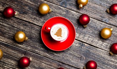 kırmızı fincan kapuçino ahşap masa üzerinde Noel baubles ile