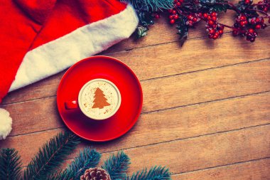 ahşap masa Cappuccino ve Noel şapka kırmızı fincan.