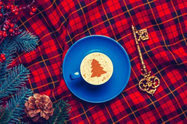 Kapuçino mavi bardak krem Noel ağacı ve çam dalı ile anahtar tartan zemin üzerine ile