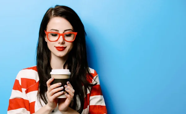 青の背景にコーヒーのカップを持つ美しい若い女性の肖像画 — ストック写真