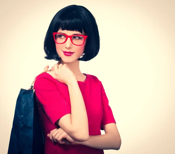 メガネとバッグと赤いドレスでスタイルの流行に敏感な女の子 — ストック写真