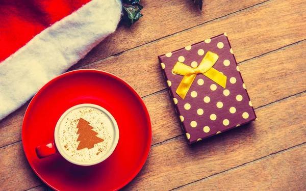 Kırmızı Fincan Cappuccino Noel Şapka Ahşap Masa Hediye — Stok fotoğraf